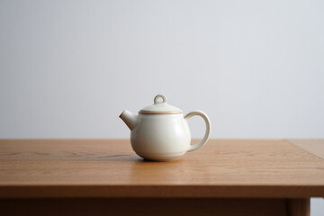 Small Teapot on Wooden Table in Neutral Setting Ideal for Tea Time and Warm Beverage Presentation in Simple Style