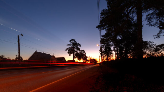 Long time exposure on a highway with car light trails on blue hour. Tracks from car headlights on the road on a spring morning