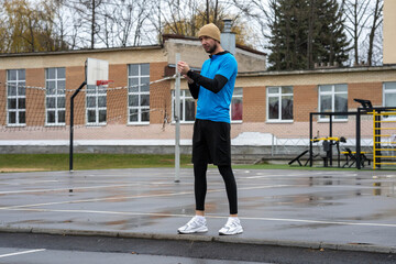 Runner checking smartwatch on a wet outdoor track