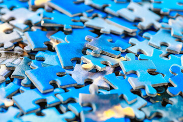 Jigsaw puzzle pieces.Colorful background with small puzzle pieces, messy.Some colored pieces of puzzle as background.Challenge and solution concept. Hobbies and leisure activities