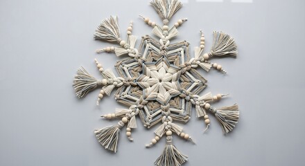 Decorative snowflake ornament made of natural fibers on grey background  