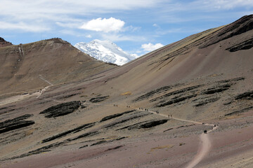 The snow-covered Auzangate mountain looming over hikers going to see the Rainbow Mountain (Vinicuna).  Located in Peru.