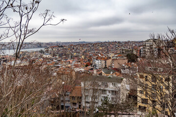 Obraz premium Rooftop view of Beyoğlu's historic architecture along the Golden Horn under gray skies, capturing the layered essence of old Istanbul. Turkey.