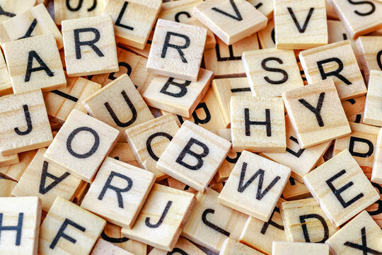 Alphabet letters on wooden block pieces, from above.Close up of Wooden letter cubes.Challenge and solution concept.Hobbies and leisure activities