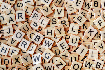 Alphabet letters on wooden block pieces, from above.Close up of Wooden letter cubes.Challenge and...