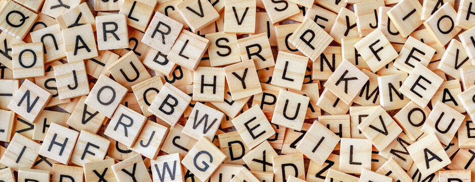 Alphabet letters on wooden block pieces, from above.Close up of Wooden letter cubes.Challenge and solution concept.Hobbies and leisure activities