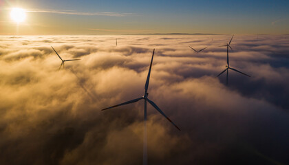 Wind Turbines Generating Renewable Energy Above Foggy Clouds at Sunrise
