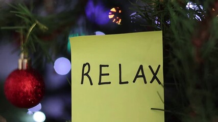 Una toma de una nota con la palabra relajarse en un fondo de luces de colores desenfocadas
