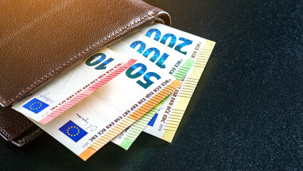 Various currencies in purse close-up.Open wallet with euro banknotes.British coins , pound sterling.Dollars cash and credit cards.Finance concept