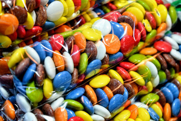 Colorful chocolate candies sweets stack abstract sugar food background pattern.