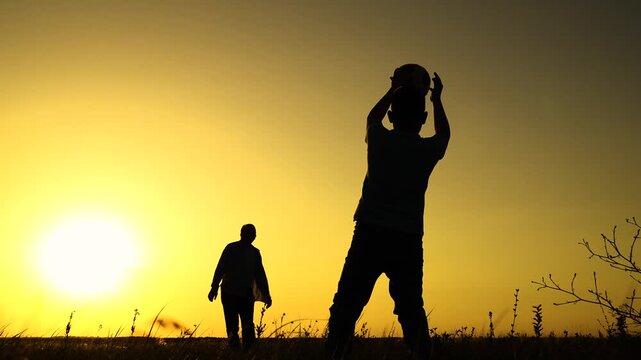 Boy child goalkeeper dad kicks ball, goal. Child son play football with father on lawn. Family team, sports games. Active happy family. Son dad having fun playing ball on green grass. Family kid sport