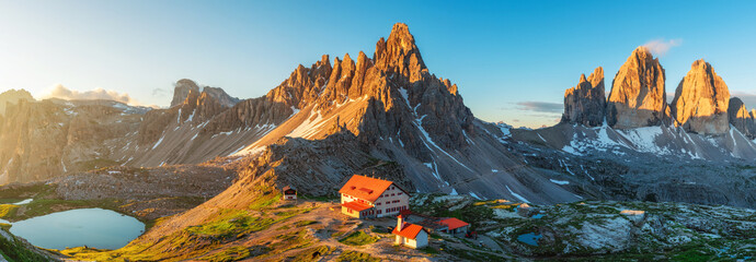Mountain sunrise at Tre Cime di Lavaredo National park and rifugio Locatelli with mountain lake in Dolomites Alps, Trentino Alto Adige, Italy. Panoramic landscape with huts, lake and rock