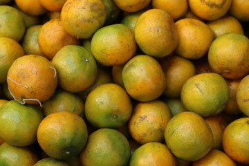 A close-up, full-frame shot of a large pile of tangerines.