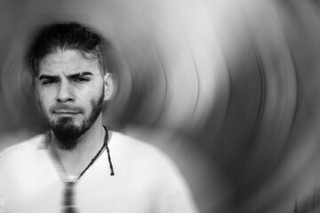 Adult male with calm expression in artistic textured background and soft motion blur.