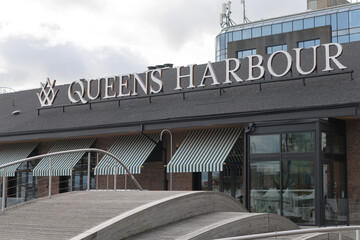 Fototapeta premium exterior building and sign of Queens Harbour, a Mediterranean restaurant, located at 245 Queens Quay W, Toronto