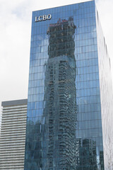 Fototapeta premium reflection of SkyTower at Pinnacle condominium complex on a modern office building with LCBO sign, 100 Queens Quay E, Toronto