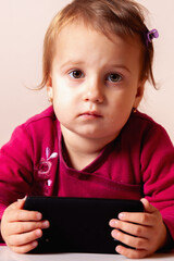 Child looking happy while using a touchscreen device.
