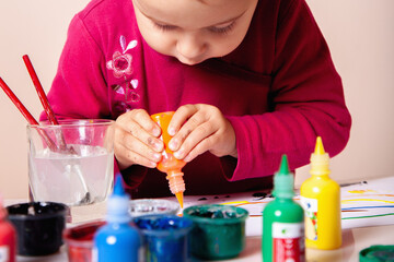 Small child deeply focused on her artistic project.