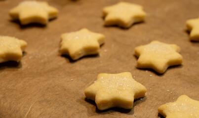 Raw star shaped cookies on baking paper
