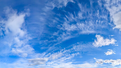 Panorama blue sky with white fluffy clouds. Copy space on panorama of cumulus and cirrus arc clouds drifting calmly across the sky toward the viewer. A majestic spectacle of nature's elements.
