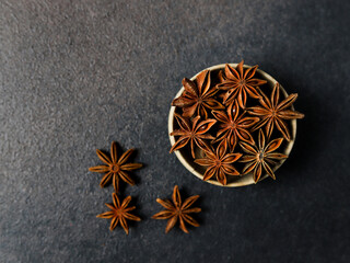 Star Anise in Wooden Bowl on Dark Textured Background