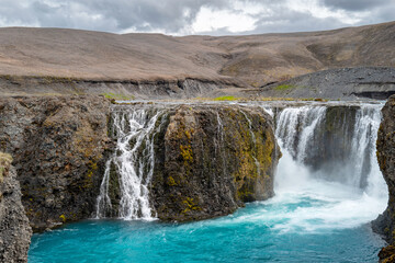 Iceland Travel: Sigoldufoss waterfall cascading into the turquoise river to Hrauneyjalon lake in the Highlands of Iceland in summer