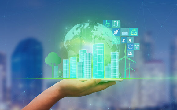 Green city Net zero emissions concept.Man hands holding mobile phone on blurred city as background