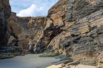 Corner of the cliffs at the famous Las Catredrales beach in Ribadeo, with its rock formations worn away by the water, layered Rock structure or texture
