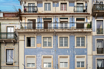 Fototapeta premium Typical old buildings in Lisbon's lower town, with their windows with balconies, lanterns, and decorative tiles. Lisbon, Portugal, 2023