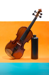 Still life with a violin and a bottle on a colored background
