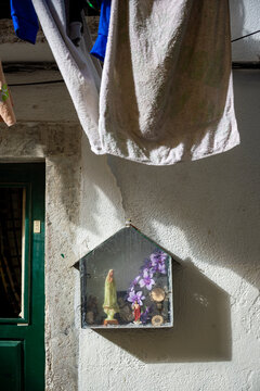 Typical tradition idol cabinet containing sentimental curios and religious artefacts such as statues of saints and Jesus and Mary on a street in Lisbon, Portugal