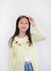 Trendy young Asian girl in pastel yellow cardigan against white background, pushing her stylish...