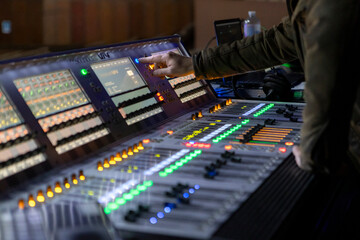A sound engineer works at a digital mixing console at a concert.