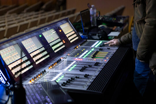 A sound engineer works at a digital mixing console at a concert.