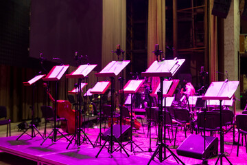 Music stands with sheet music on stage before a concert