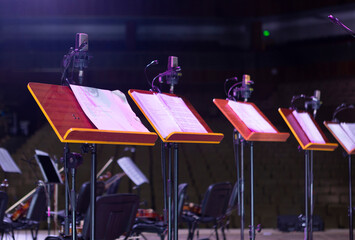 Music stands with sheet music on stage before a concert