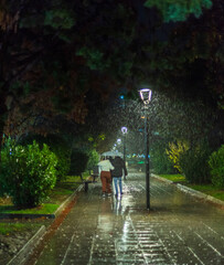 young couple walking in the rainy night