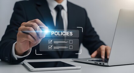 Businessman reviewing policies on digital screen with stylus and laptop