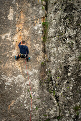 Obraz premium Person rock climbing on cliff face at high angle