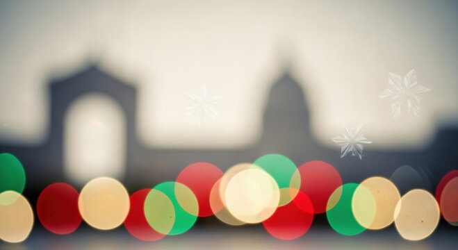 Vibrant bokeh lights in red, green, and gold with a softly blurred city silhouette and delicate snowflakes, perfect for a festive winter holiday background.