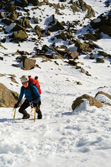 Portrait of a female mountaineer climbing a snowy couloir