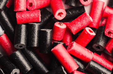 Close-up of red and black licorice candy pieces scattered randomly