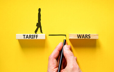 Trade tariff wars symbol. Concept word Tariff wars on beautiful wooden blocks. Beautiful yellow...