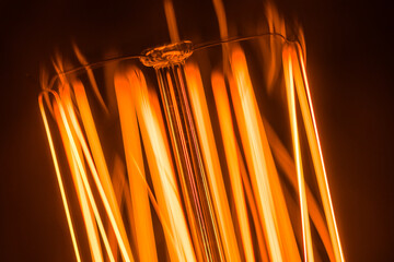 A macro close-up of an incandescent bulb shows a vivid orange filament glow