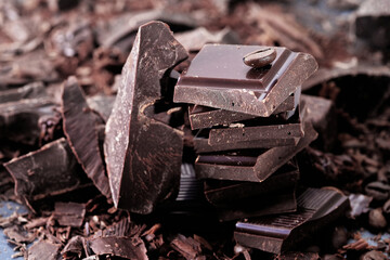 Broken dark chocolate and coffee beans on a wooden table