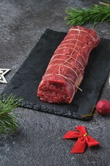 Beef tenderloin, tied with kitchen string and prepared for roasting. Holiday dishes. Cooking beef in the oven as a whole piece. Merry Christmas.