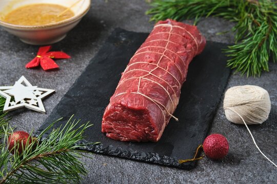 Beef tenderloin, tied with kitchen string and prepared for roasting. Holiday dishes. Cooking beef in the oven as a whole piece. Merry Christmas.