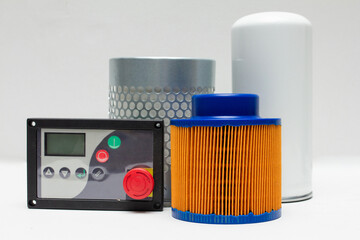 Industrial compressor control panel and various air/oil filters (orange, white, silver) displayed together. Concept illustrating compressor maintenance, parts supply, and control technology. Perfect f