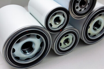 New automotive oil filters arranged in a close-up mechanical pattern, showing texture and engineering details. Essential maintenance concept for garage and auto shop websites, presentations, and repai