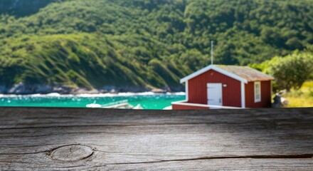 Red boathouse by turquoise water behind a weathered wooden deck adding coastal charm